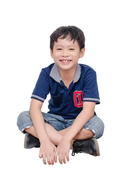 Niño sentado y sonríe sobre blanco — Foto de Stock