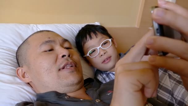 Чоловік і його дитина грають зі смартфоном — стокове відео