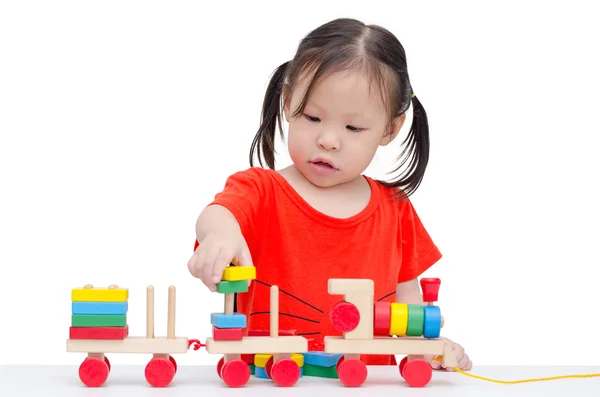 Menina brincando com trem de madeira brinquedo — Fotografia de Stock