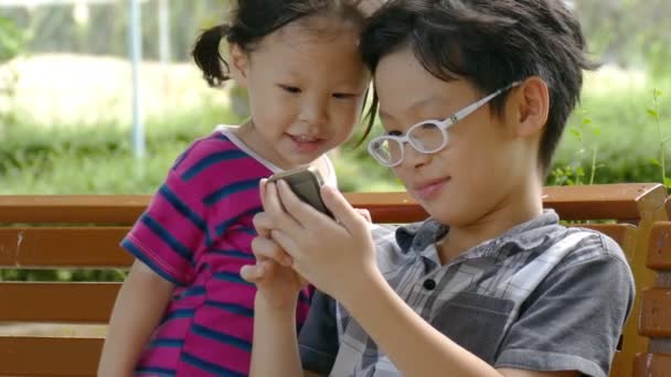Брати і сестри грають у гру на смартфоні — стокове відео