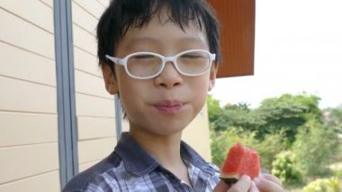 bir dilim karpuz yiyen çocuk