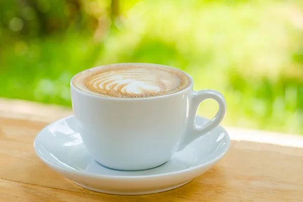 Φλιτζάνι καφέ πάνω από το Θάμπωμα φόντου φύση — Φωτογραφία Αρχείου