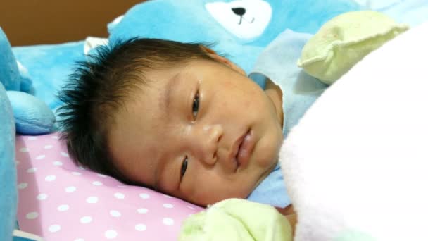 Новорожденный ребенок улыбается на кровати — стоковое видео