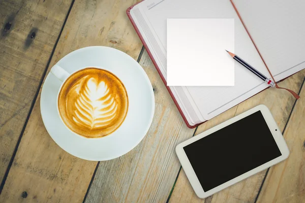 Coffee cup with notebook and smart phone on table — Stock Photo, Image
