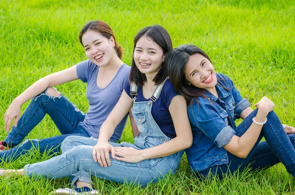 草原と笑顔で座っている 3 人の女性 — ストック写真