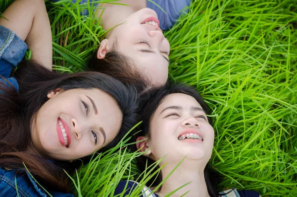 Meninas deitadas no campo de grama na hora de verão — Fotografia de Stock