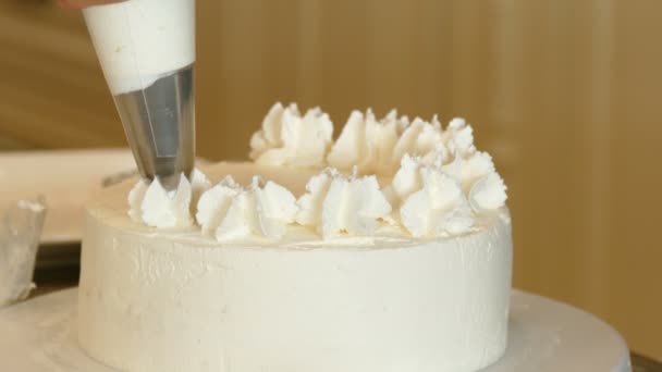 Baker zdobí vanilkový dort — Stock video