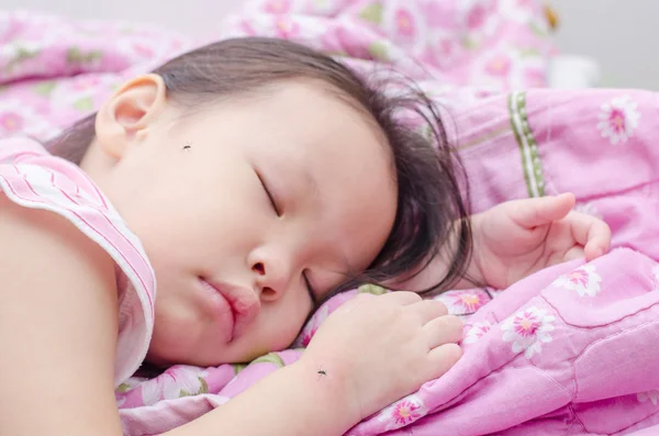 Девушка спит на кровати и кусается комарами — стоковое фото