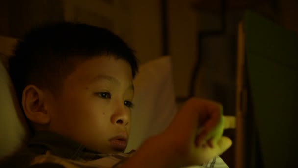 Niño jugando juegos en la cama — Vídeo de stock