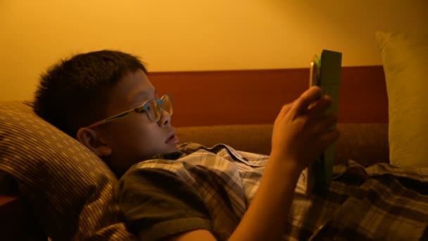 Young boy playing games on bed — Stock Video