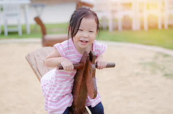 Bambina che gioca barcollare al parco giochi — Foto Stock