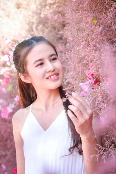 美丽的亚洲女人 穿着白色的衣服 站着美丽的粉红色花朵 微笑着 — 图库照片