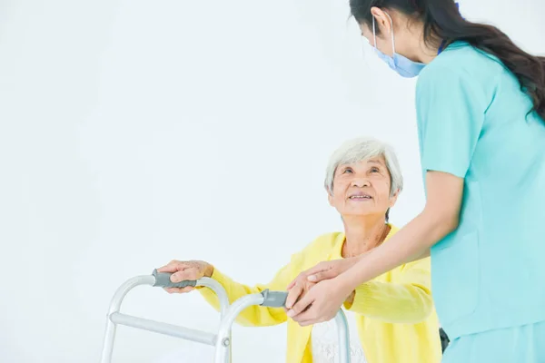 Senior Sonriendo Enfermera Que Ayuda Ponerse Pie Con Walker Casa —  Fotos de Stock