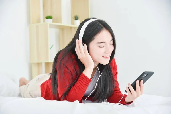 Jovem Asiático Menina Bonita Deitada Cama Ouvir Música Telefone Inteligente — Fotografia de Stock