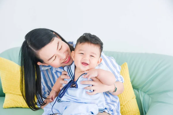 Hermosa Madre Asiática Jugando Con Pequeño Hijo Sofá Casa Imagen de stock