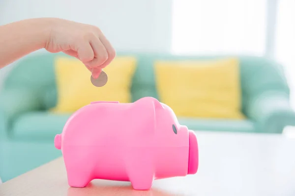 Child Hand Putting Coin Pink Piggy Bank Sofa Background — Stock Photo, Image