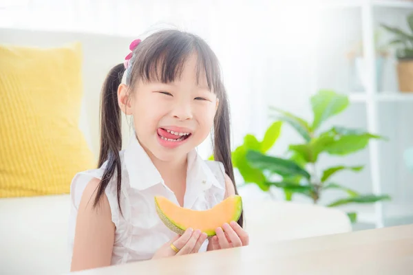 Linda Menina Asiática Comendo Melão Casa Conceito Alimentação Saudável Criança Imagens Royalty-Free