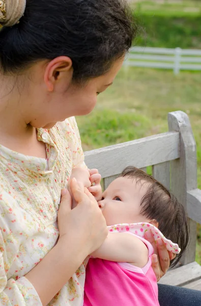 Азиатская мама кормит грудью свою малышку — стоковое фото