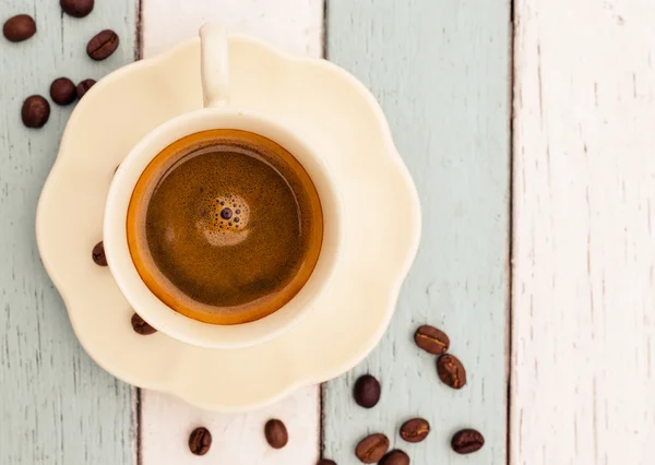 Kaffekopp og bønner på trebord – stockfoto