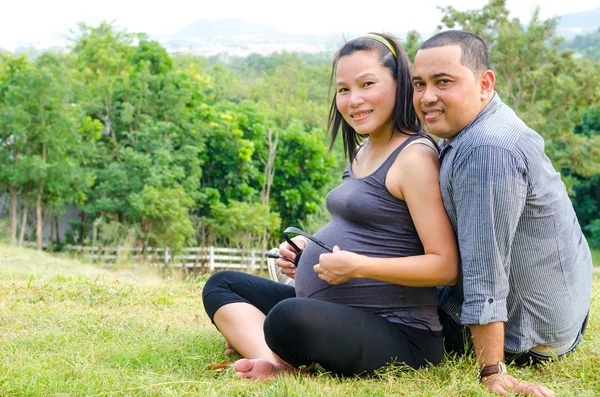 Gravid sitter i parken med sin make — Stockfoto