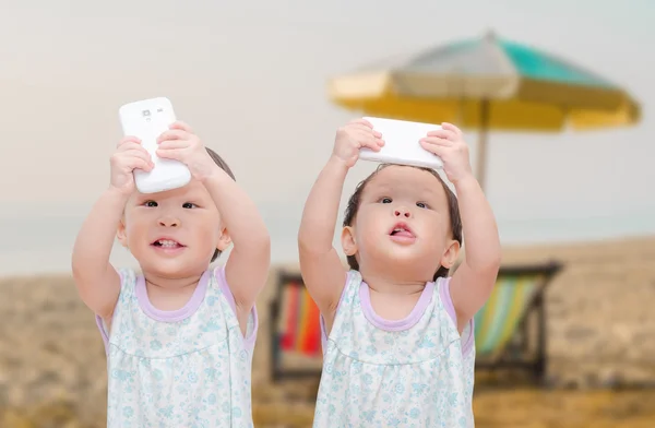 Två små flickor och tvillingar tar selfie med mobiltelefon — Stockfoto