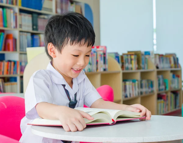 Ученик читает книгу в школьной библиотеке — стоковое фото