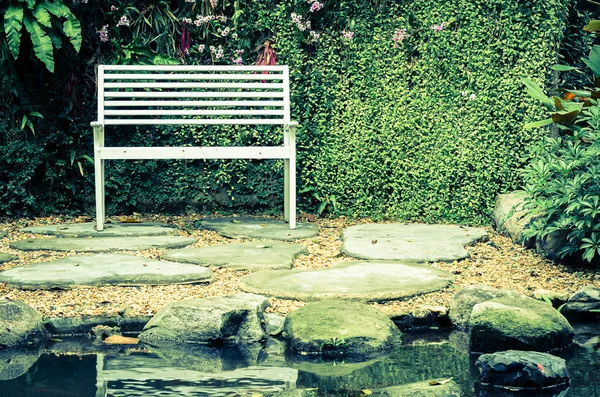 Bench in garden with vintage filter — Stock Photo, Image