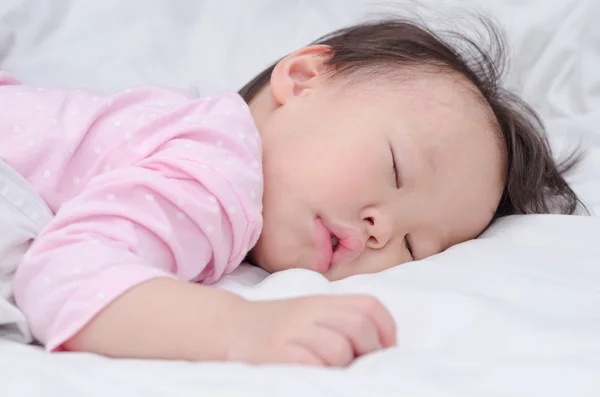 Meisje slaapt in een bed — Stockfoto