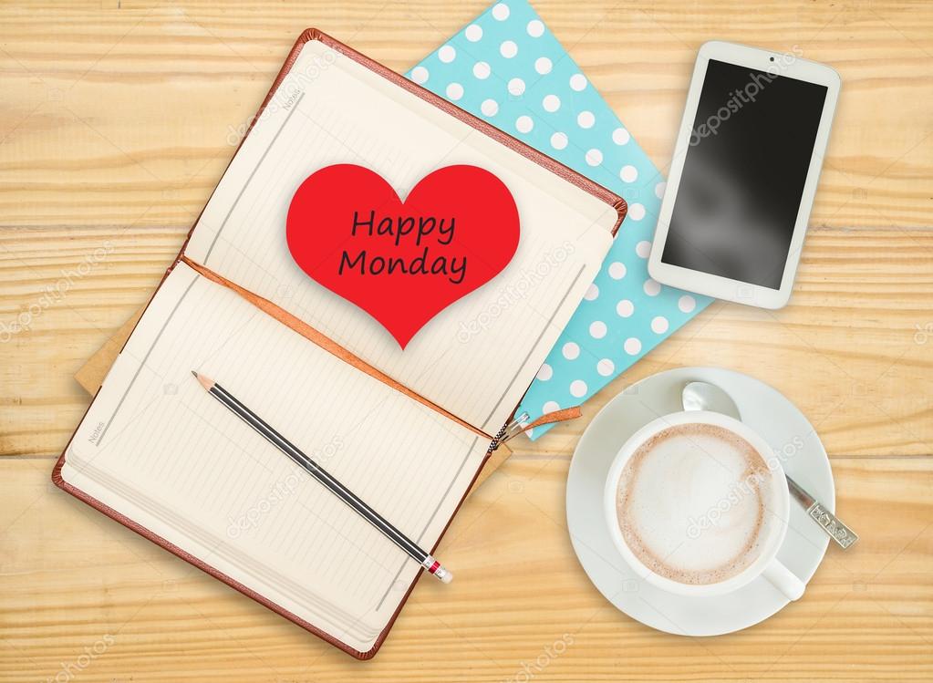 Happy monday on notebook with smart phone and coffee cup