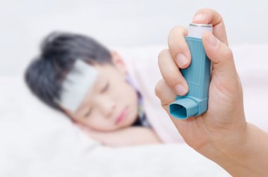 Mother holding asthma inhaler clipart