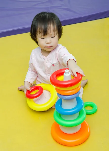 Chica jugando juguete en el suelo — Foto de Stock