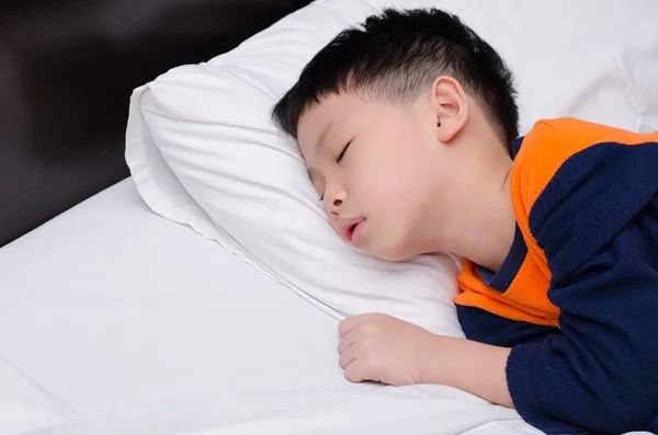 Pojken sova i en säng — Stockfoto
