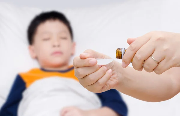 Mutter gießt Medikamente in einen Löffel — Stockfoto