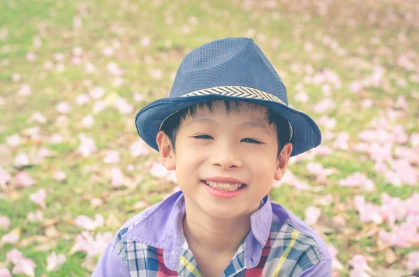 Мальчик улыбается в саду, эффект винтажного фильтра — стоковое фото