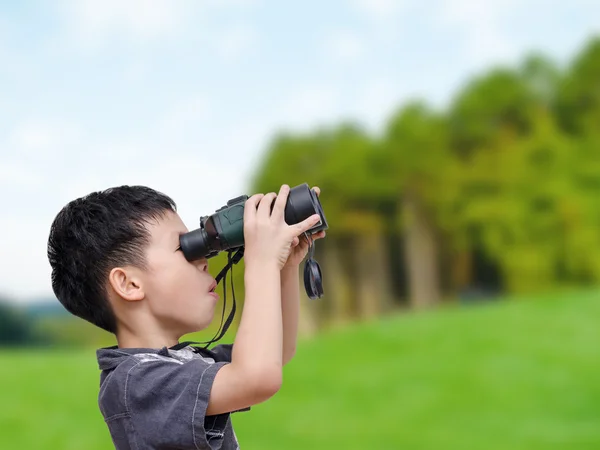 Pojke med kikare i skogen — Stockfoto
