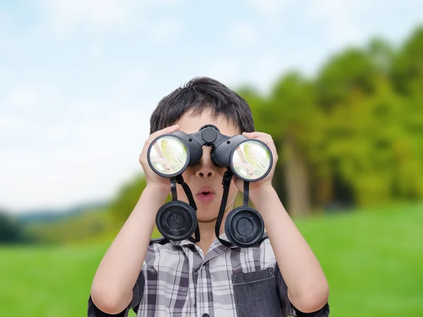 Pojke med kikare i skogen — Stockfoto