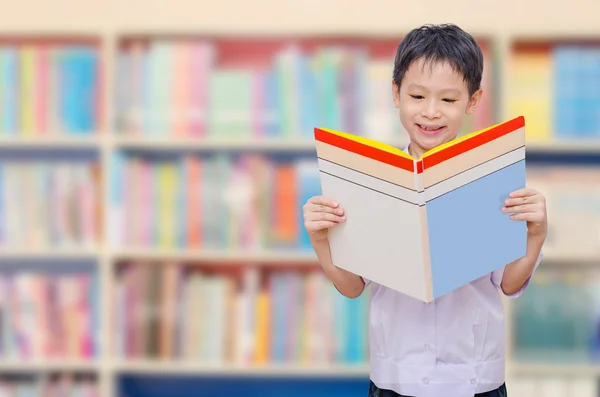 Школьник читает книгу в библиотеке — стоковое фото