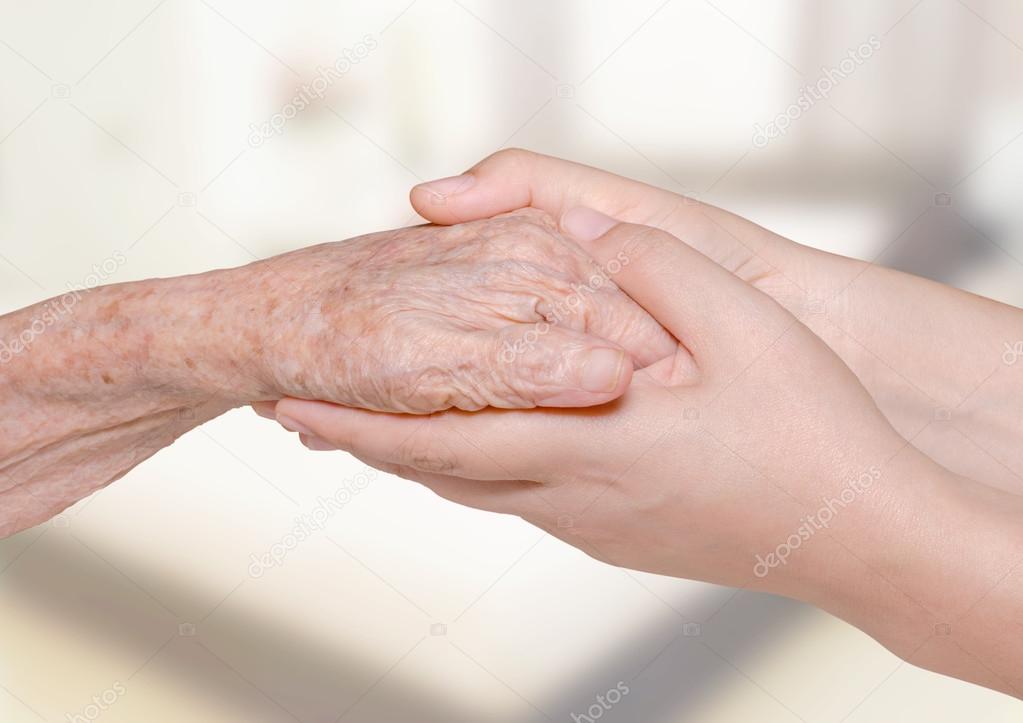 woman holding her grandma hand in bedroom
