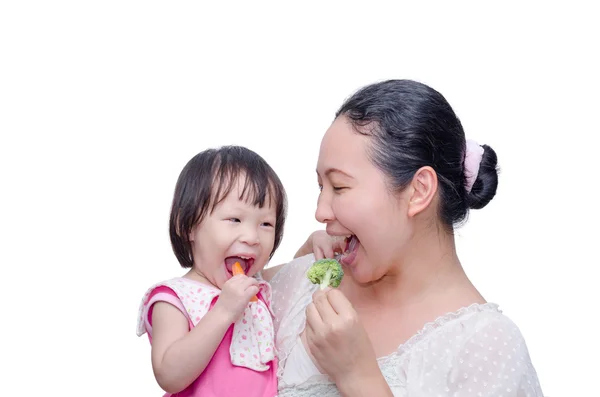 Mãe e sua filha comendo legumes — Fotografia de Stock