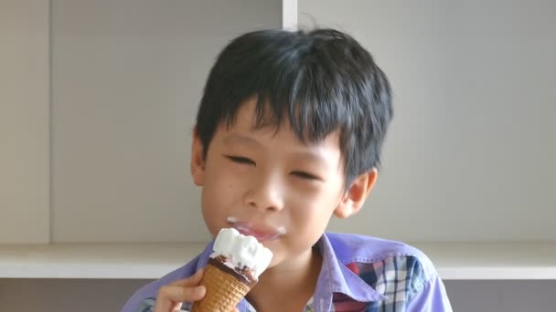 少年はアイスクリームを食べることを楽しむ — ストック動画