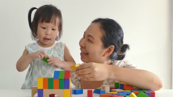 Meisje en moeder spelen met blokken op tafel — Stockvideo