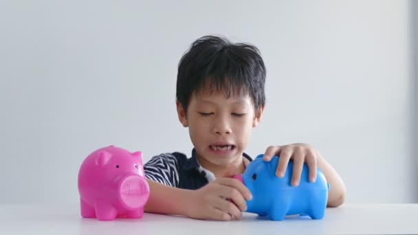 Jongen probeert te openen zijn piggy bank — Stockvideo