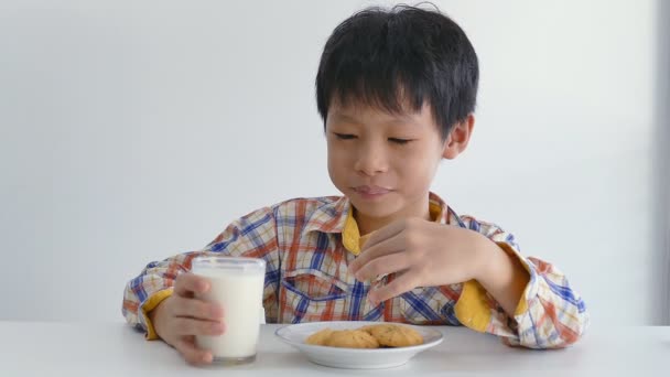 Niño comiendo galletas con leche — Vídeos de Stock