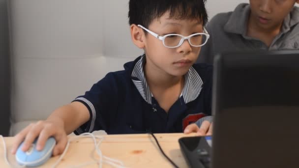 Barnen har roligt att spela på en bärbar dator — Stockvideo