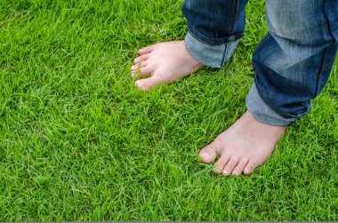 Yeşil çimlerin üzerinde çıplak ayaklar