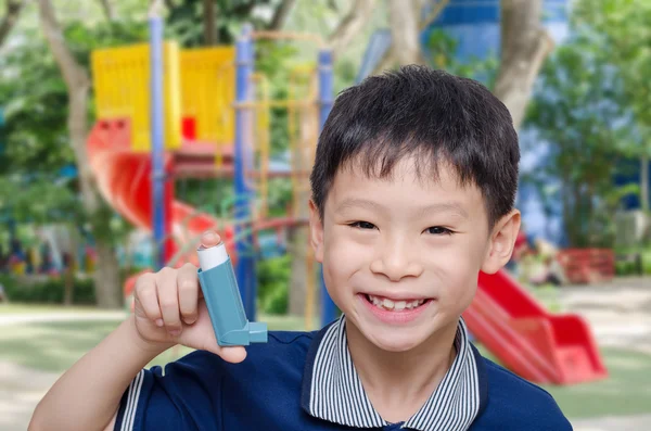 Chłopca gospodarstwa inhalator i uśmiechy — Zdjęcie stockowe