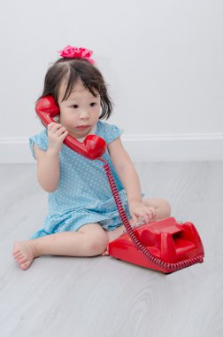 Küçük Asyalı kız yere telefon kullanma