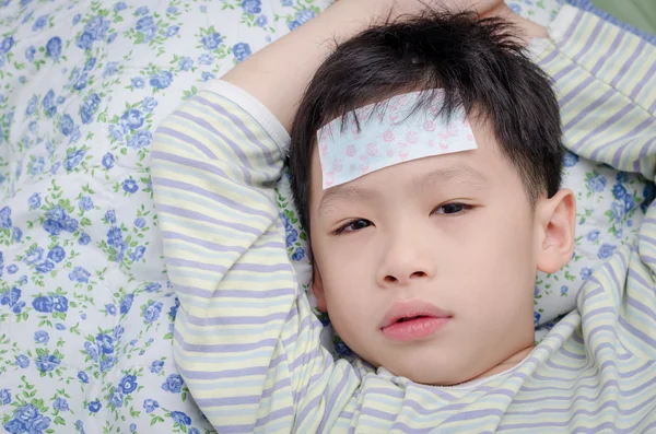 Little sick boy lying on bed — Stock Photo, Image