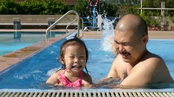 Girl and his dad have fun in swimming pool — Stock Video