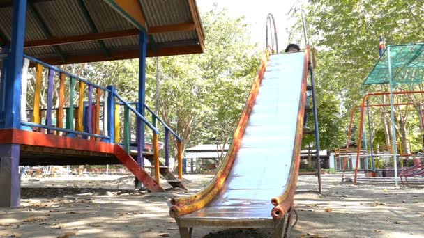 Niño jugar slider en el patio de recreo — Vídeo de stock